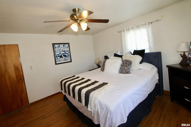 bedroom with a ceiling fan, dark wood finished floors, and baseboards