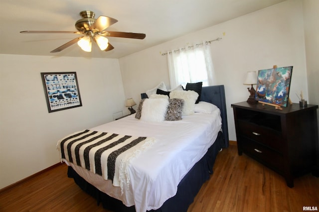 bedroom with ceiling fan, wood finished floors, and baseboards