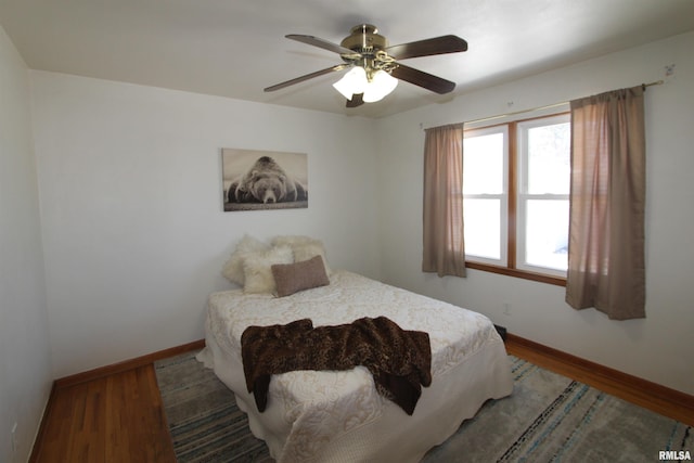 bedroom with ceiling fan, baseboards, and wood finished floors