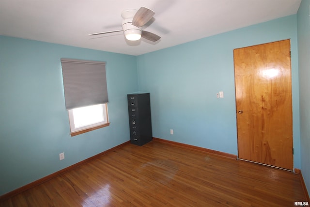 unfurnished room featuring a ceiling fan, baseboards, and wood finished floors