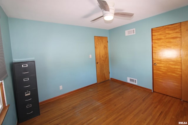 unfurnished bedroom featuring visible vents, baseboards, and wood finished floors