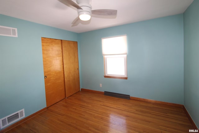 unfurnished bedroom with baseboards, visible vents, and wood finished floors