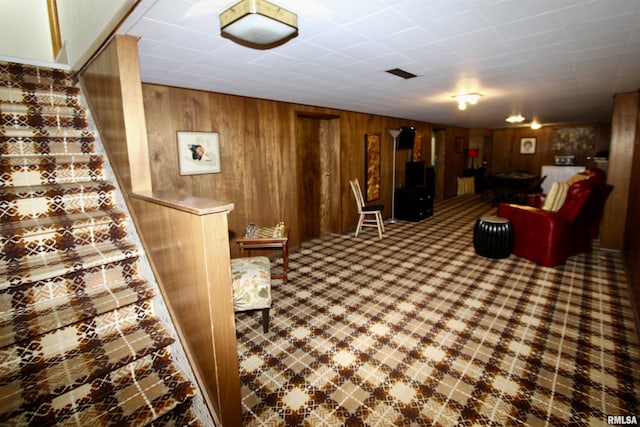 living area with stairway and wood walls