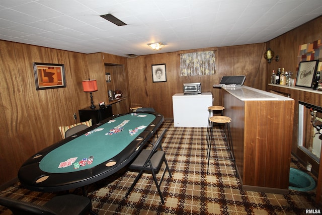 game room featuring a toaster, wood walls, and a dry bar