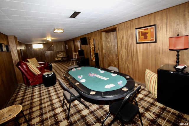 recreation room with carpet flooring and wood walls