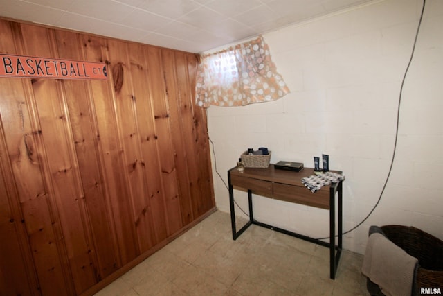 office space with light floors, concrete block wall, and wooden walls