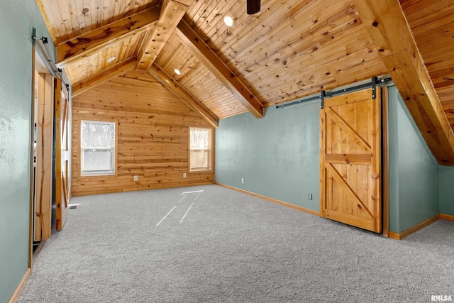 additional living space with a wealth of natural light, wooden ceiling, vaulted ceiling with beams, and a barn door