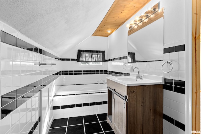 kitchen with lofted ceiling, a textured ceiling, dark tile patterned flooring, a sink, and light countertops