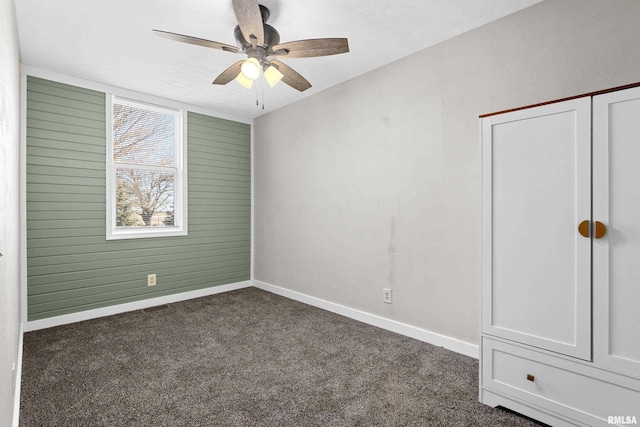 interior space featuring dark colored carpet, a closet, visible vents, ceiling fan, and baseboards