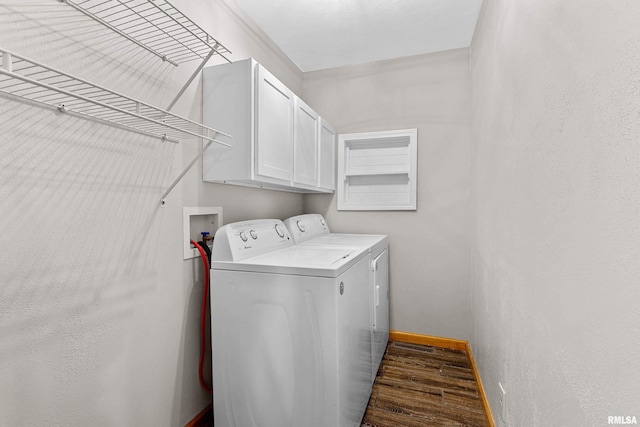 laundry area with cabinet space, baseboards, dark wood-style floors, and washing machine and clothes dryer