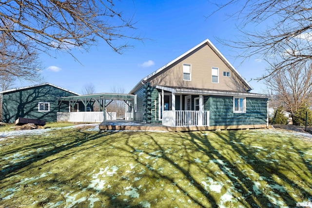 snow covered house featuring covered porch, a sunroom, and a yard