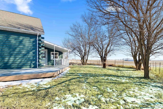 view of yard featuring fence, a deck, and a rural view