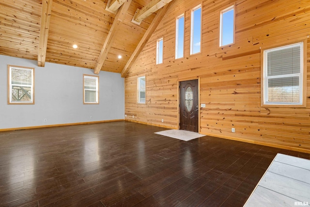 unfurnished living room with wooden ceiling, wood walls, dark wood-style floors, and beam ceiling