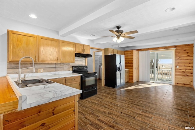 kitchen with under cabinet range hood, a peninsula, a sink, light countertops, and black appliances