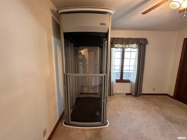 interior space featuring baseboards, carpet, visible vents, and a ceiling fan