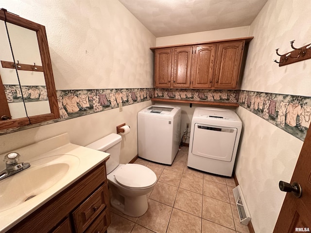 bathroom with visible vents, wainscoting, toilet, vanity, and washing machine and dryer