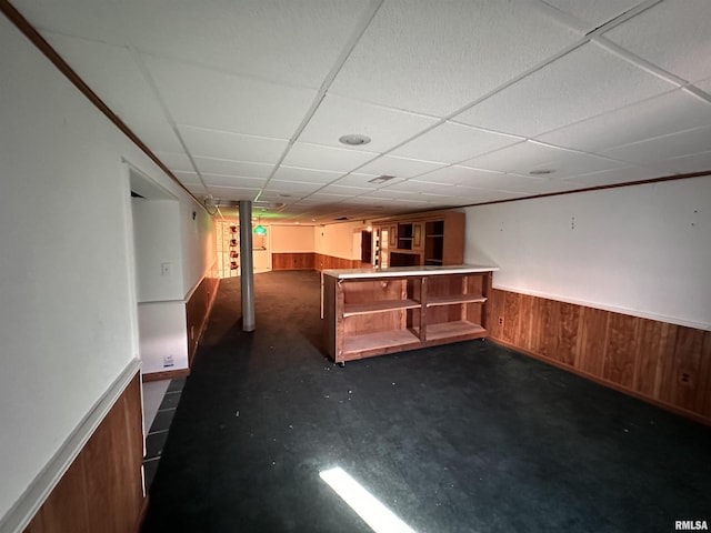 bar with a bar, wood walls, wainscoting, and a paneled ceiling