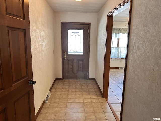 doorway featuring a textured wall and a wealth of natural light