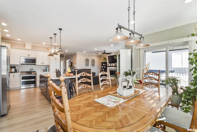 dining space with a ceiling fan, recessed lighting, a fireplace, and ornamental molding