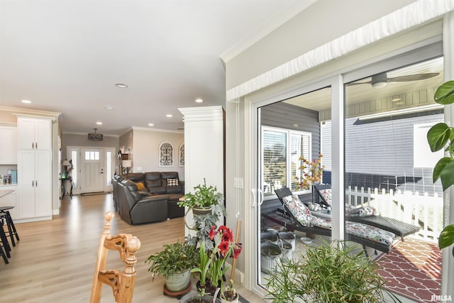 living area featuring light wood-style floors, plenty of natural light, recessed lighting, and crown molding