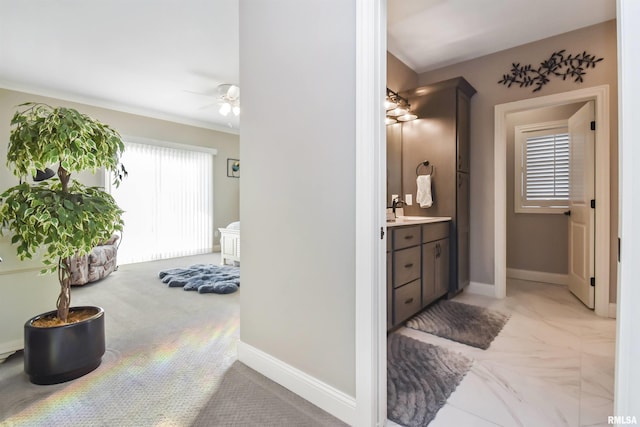 bathroom with ceiling fan, vanity, and baseboards