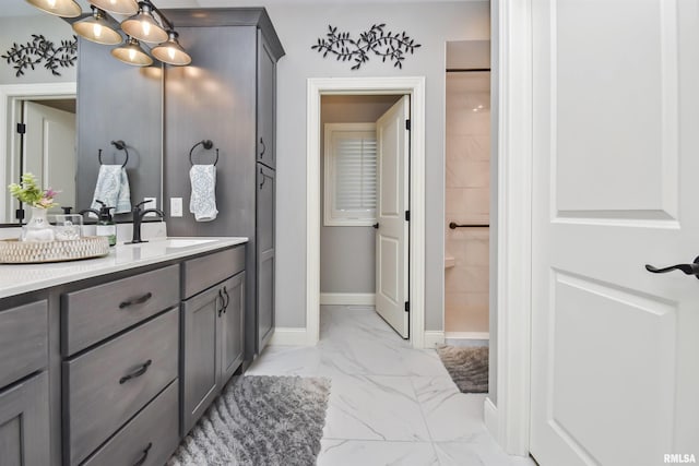 full bath with marble finish floor, vanity, and baseboards