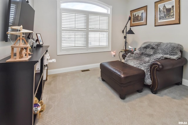 sitting room with light carpet, visible vents, and baseboards