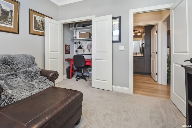 living area featuring light carpet and baseboards