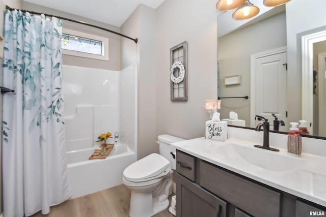 full bath featuring wood finished floors, shower / bath combo, vanity, and toilet