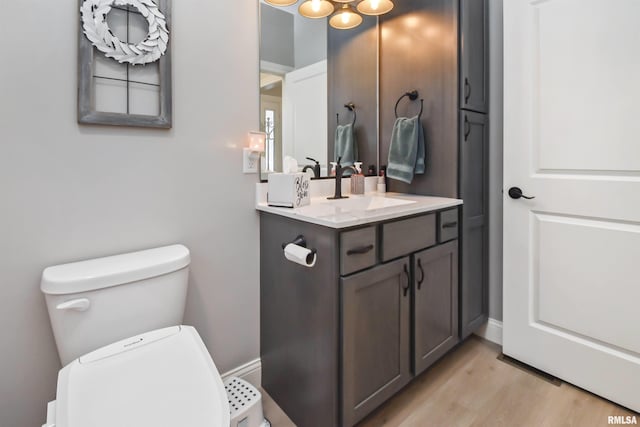 bathroom featuring vanity, toilet, and wood finished floors