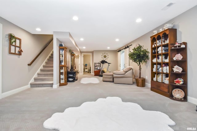 interior space featuring light carpet, a barn door, visible vents, stairs, and recessed lighting