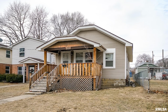 view of front of house featuring a porch, a front yard, and fence