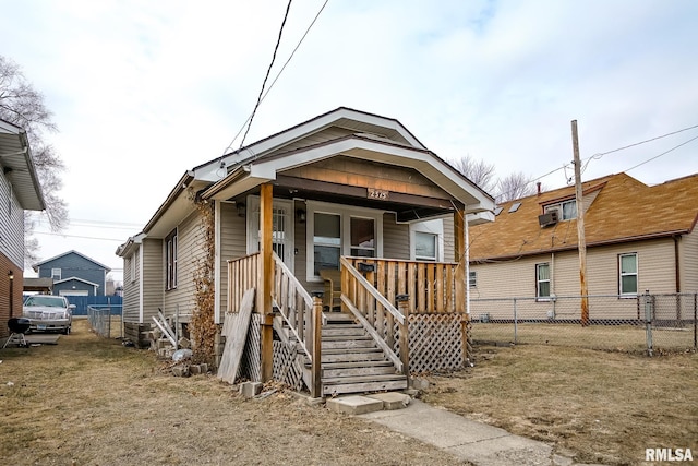 view of front of house featuring a porch, a front yard, and fence