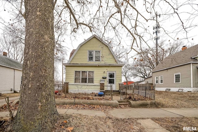 view of front of property with a fenced front yard and a gambrel roof