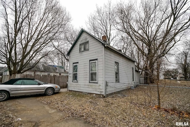 view of home's exterior with fence and a chimney