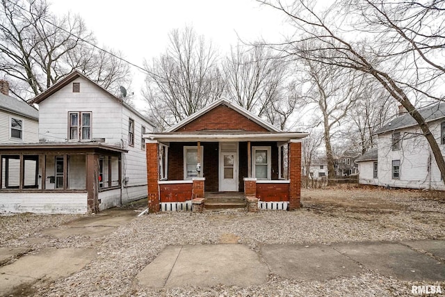 view of front facade featuring brick siding and a porch