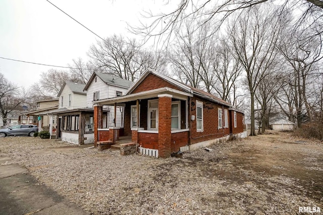 view of front of home with a porch and brick siding