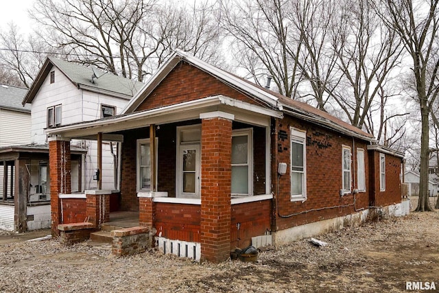 view of property exterior with covered porch and brick siding