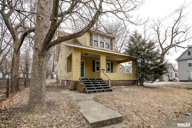 view of front of house featuring covered porch and fence