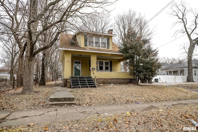 bungalow-style house featuring covered porch, a chimney, and fence