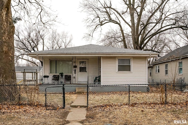 bungalow-style home featuring covered porch, a fenced front yard, a gate, and a shingled roof