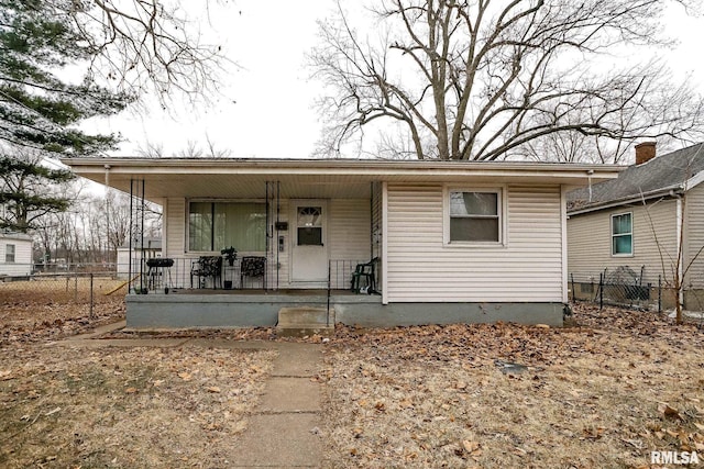 bungalow-style home featuring covered porch and fence