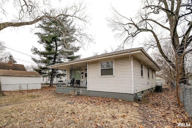 bungalow-style house featuring fence, a porch, and central AC