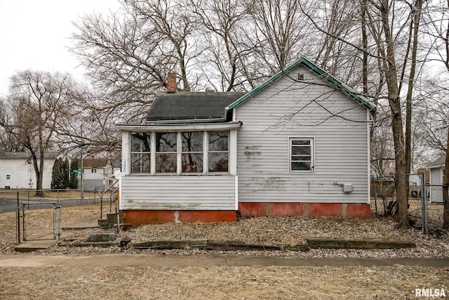 exterior space with a sunroom, fence, and a chimney