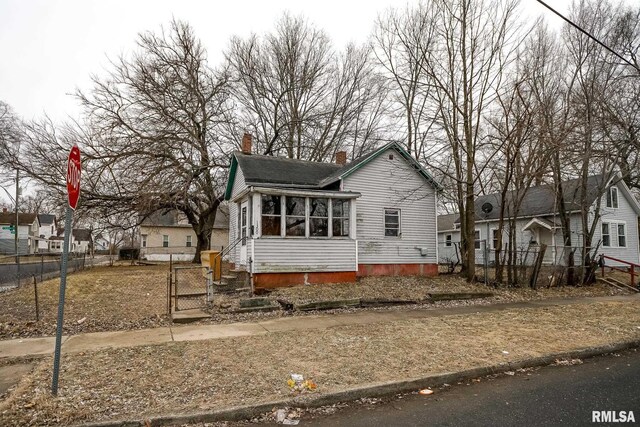 bungalow-style house with a residential view, a gate, fence, and a chimney