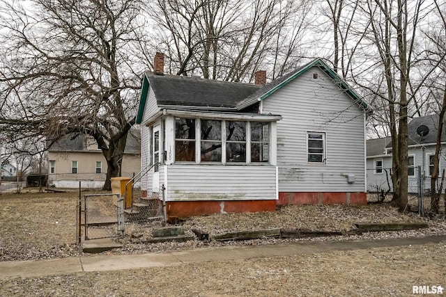 view of front of property with a gate, roof with shingles, fence, and a chimney