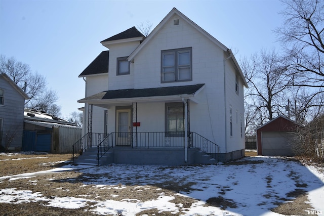 view of front of property with covered porch, roof with shingles, a detached garage, and an outdoor structure