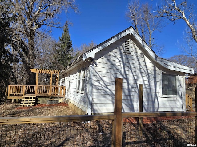 view of side of home with a pergola and a wooden deck