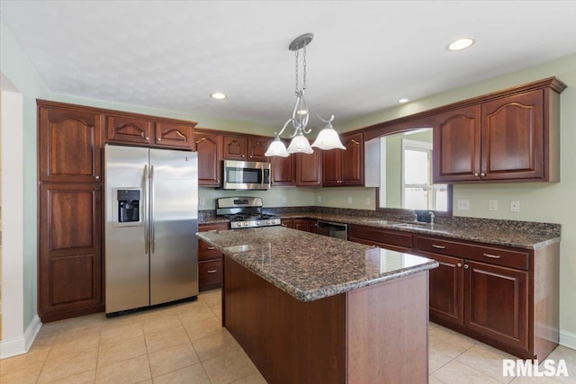 kitchen featuring appliances with stainless steel finishes, decorative light fixtures, a center island, a sink, and recessed lighting