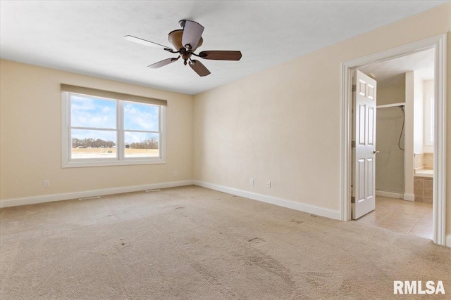 empty room featuring light carpet, ceiling fan, and baseboards